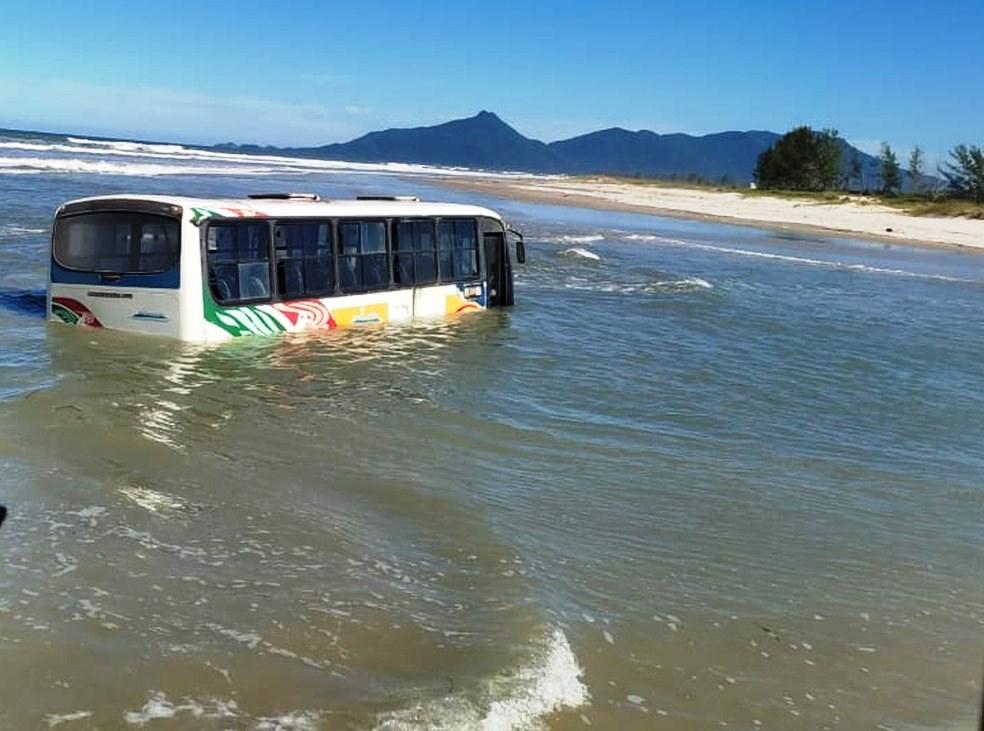 Ônibus fica atolado em praia durante ressaca e chega a ficar 80% coberto pela água