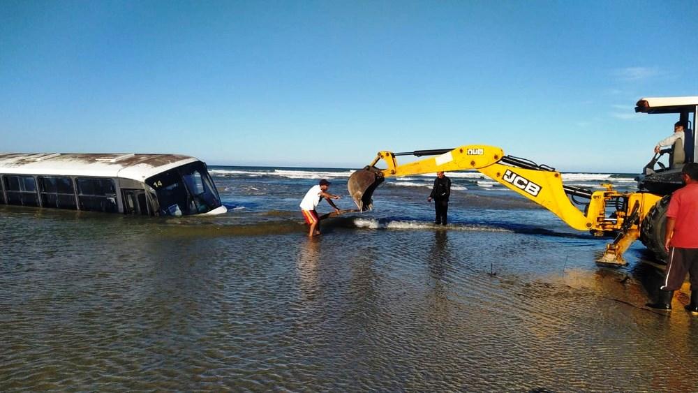 Ônibus fica atolado em praia durante ressaca e chega a ficar 80% coberto pela água