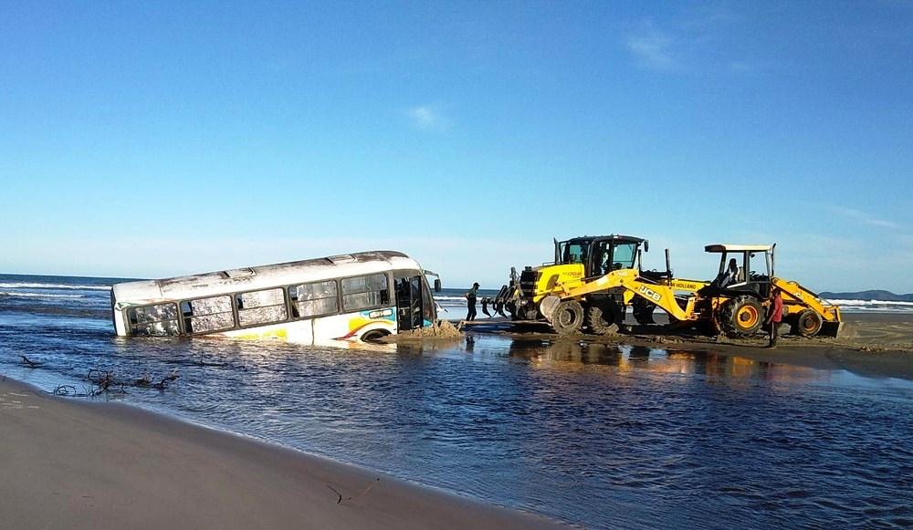 Ônibus fica atolado em praia durante ressaca e chega a ficar 80% coberto pela água