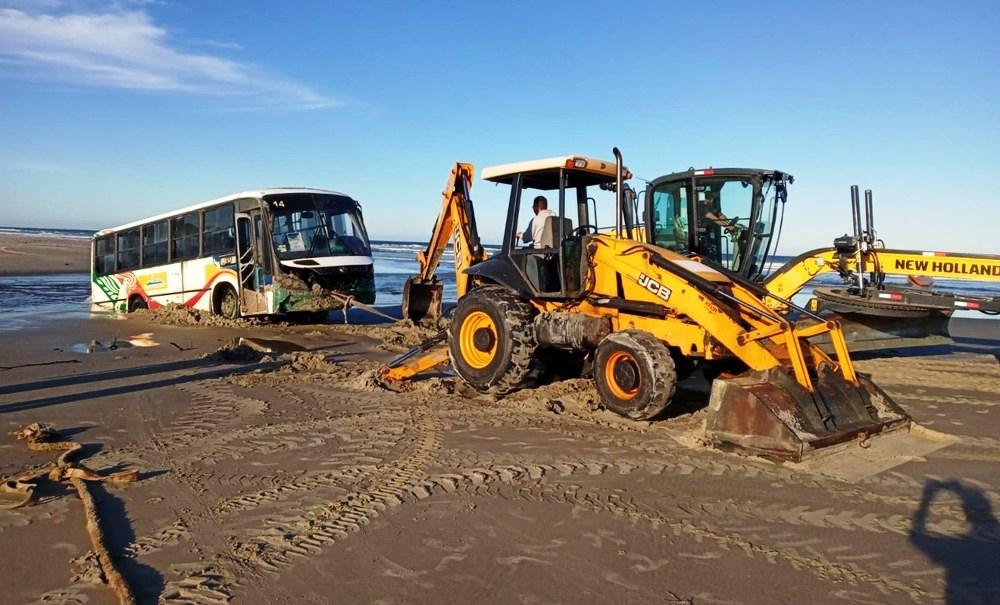 Ônibus fica atolado em praia durante ressaca e chega a ficar 80% coberto pela água