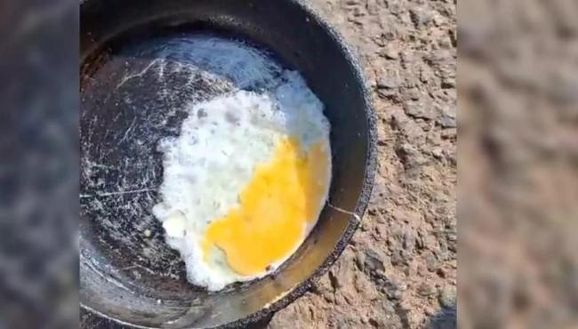 Morador frita ovo em frigideira no meio da rua