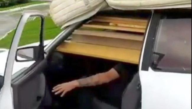Motorista dirige ‘escondido’ por tábuas em carro sobrecarregado