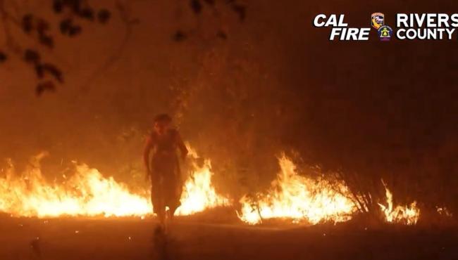 Mulher é resgatada após surgir entre as chamas de incêndio