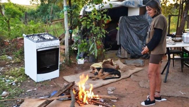 Mulher vive há quase dois anos em barraco de lona e improvisa fogueira para escapar do frio