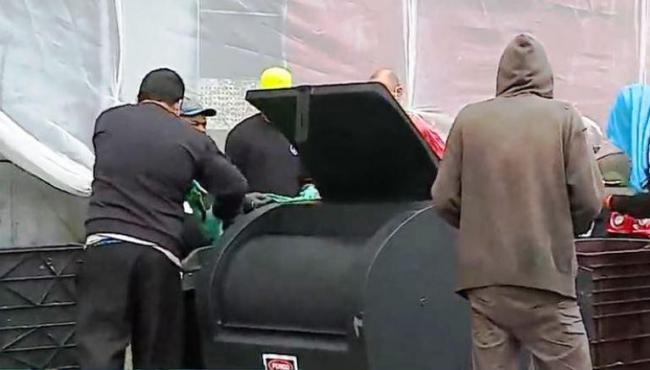 Pessoas fazem fila para pegar restos de comida no centro de SP