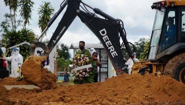 Retroescavadeiras viram coveiros e famílias têm 5 minutos para enterrar parentes, em Manaus